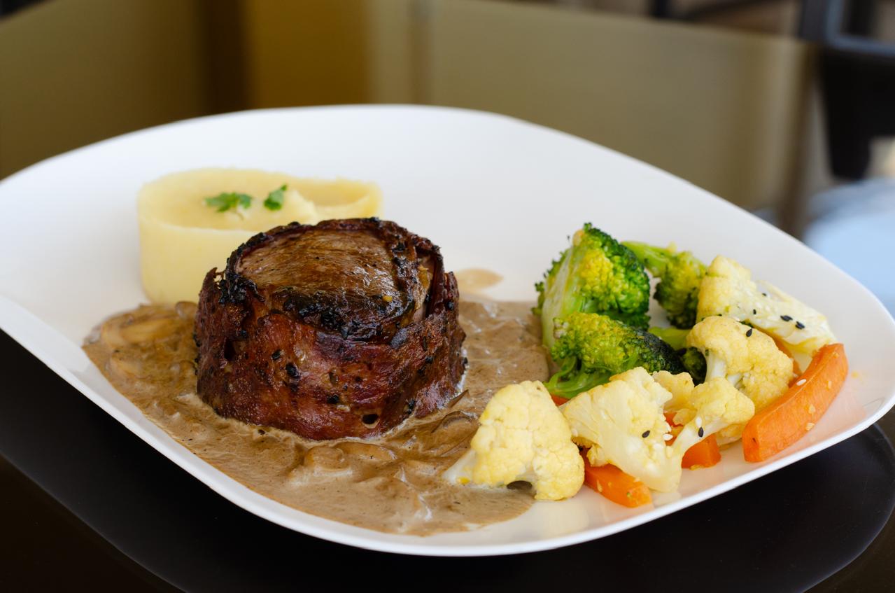 Filet mignon envuelto en tocino con salsa de hongos y vegetales